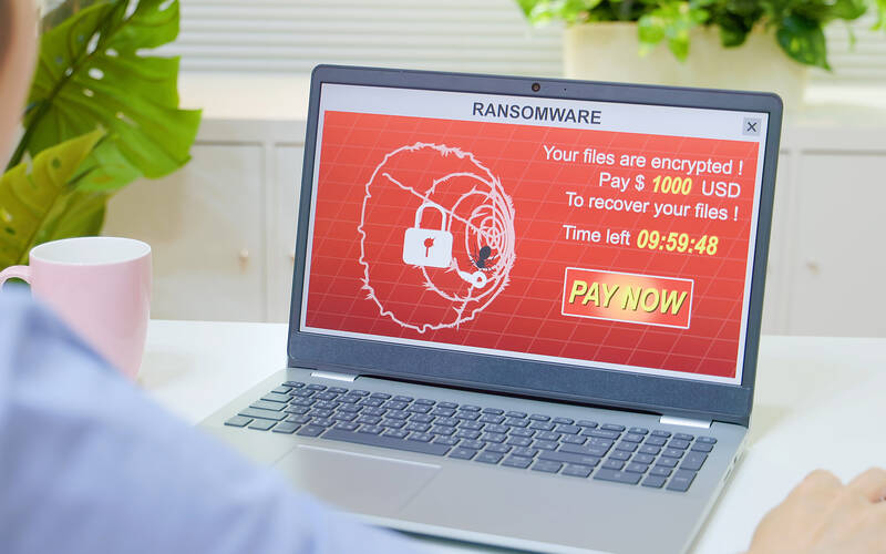 user operating laptop with ransomware on screen