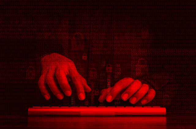 red tinted hands typing on a keyboard