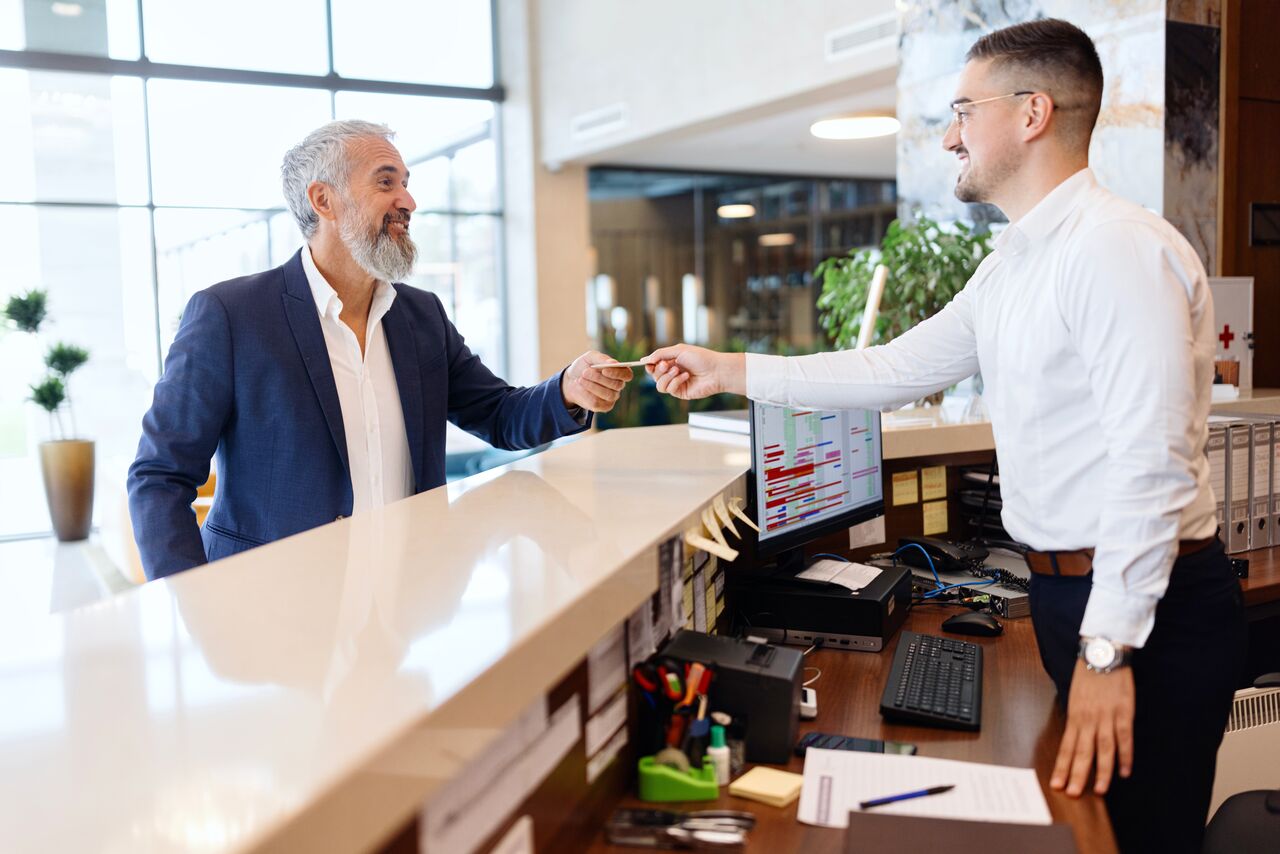 Hotel clerk taking credit card from customer