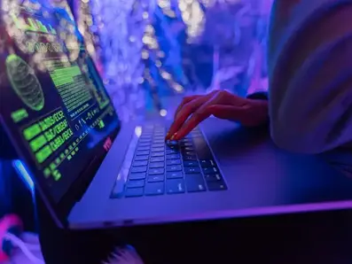 Computer user working with blue and purple tinting over image