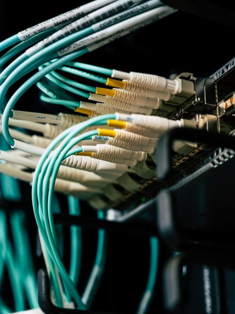 Detailed view of network cables plugged into a server rack in a data center.