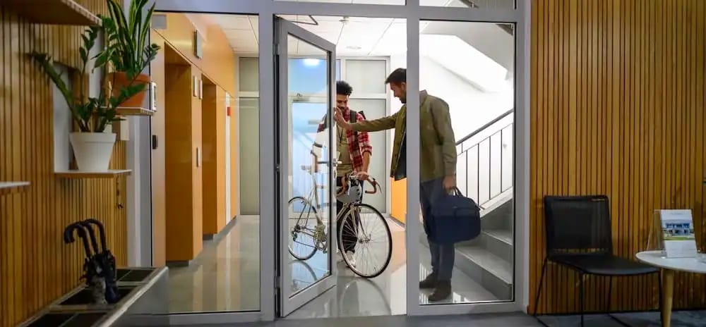 Unsuspecting employee holding door for a tailgater